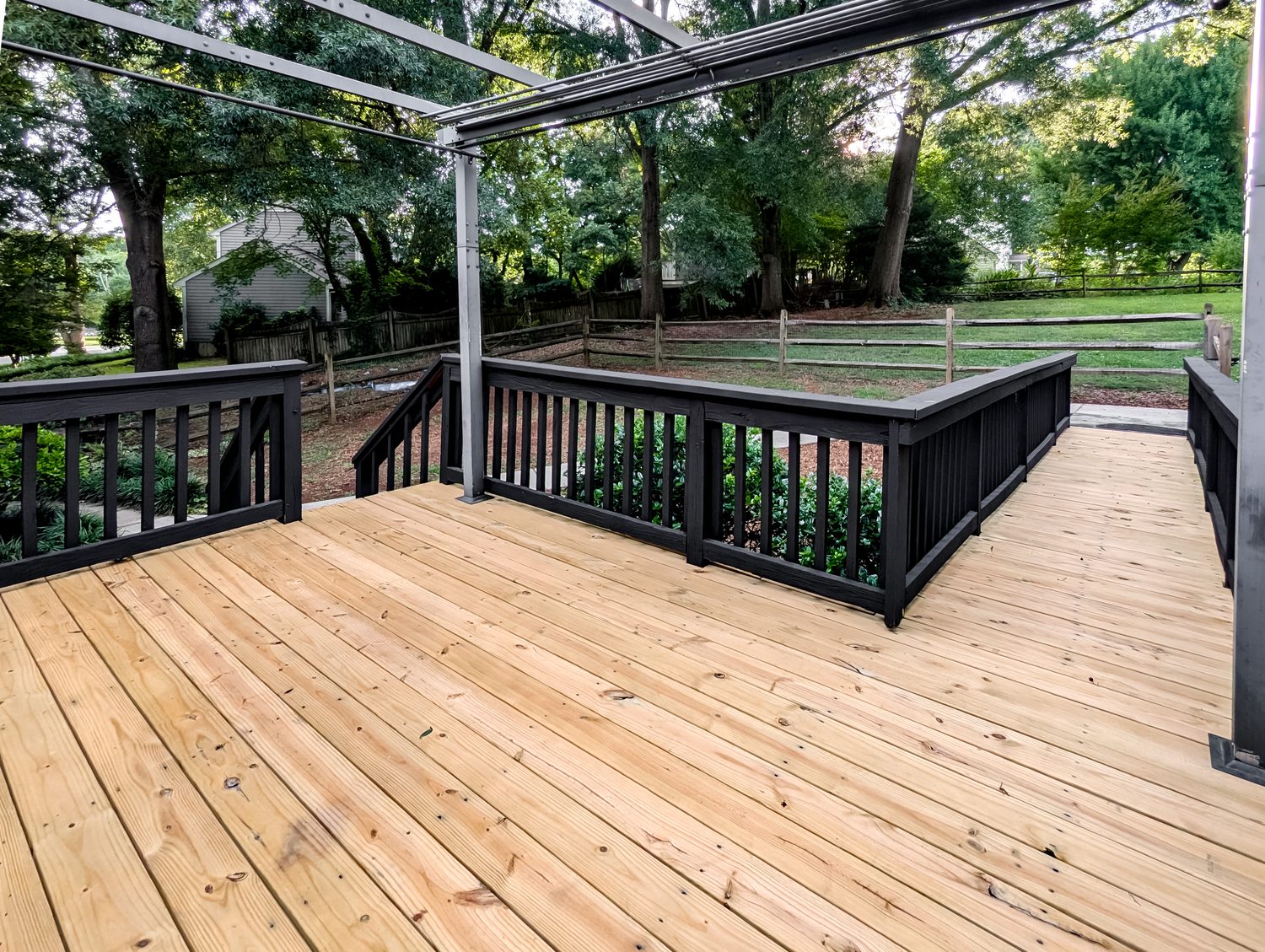 Rear deck with pergola frame and black railing